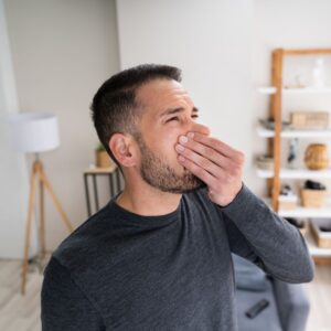 a person holding their nose reacting to a bad smell