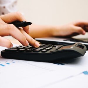 a person doing paperwork with a calculator