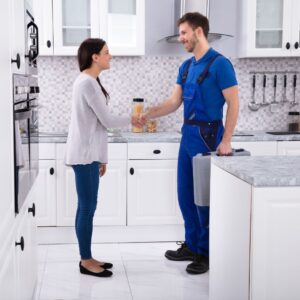 a worker and woman shaking hands in a kitchen