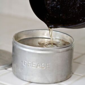 a person pouring kitchen grease into a container