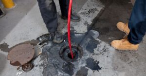 a team putting a hose down a drain