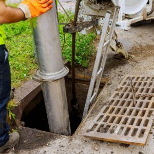 workers putting a large tube down a sewer pipe