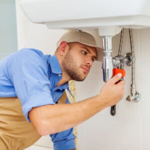 a plumber working on sink pipes