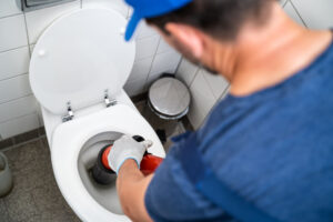 plumber unclogging toilet Seattle, WA